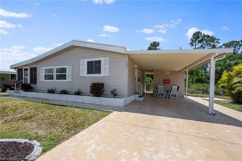 Manufactured / mobile home with entry steps, an attached carport, and concrete driveway