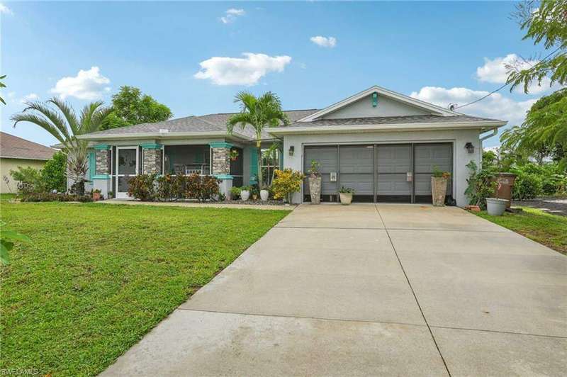 Ranch-style home featuring a front lawn and a garage