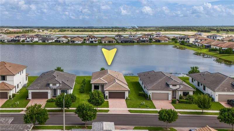 Aerial perspective of suburban area featuring a nearby body of water