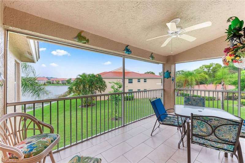 Patio / terrace featuring ceiling fan, a water view, and a lawn