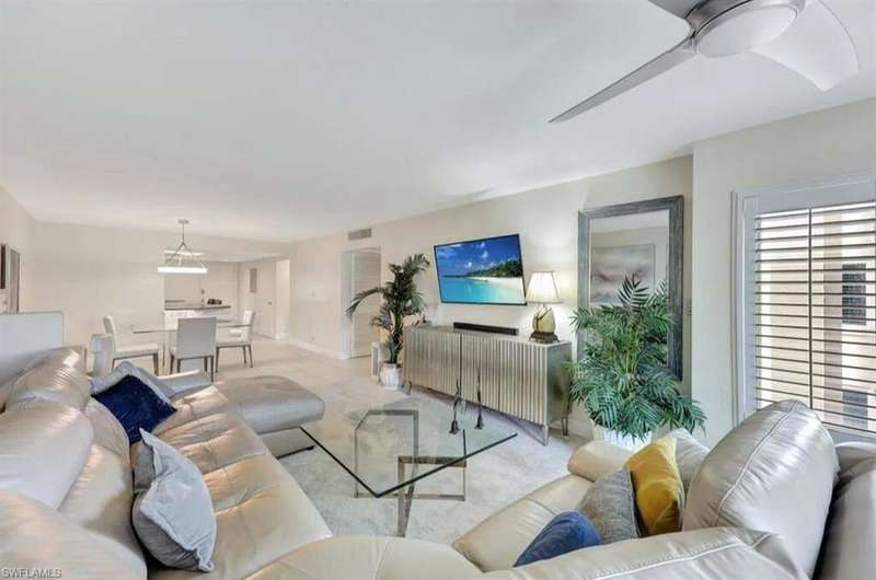 View of apartment building / complex featuring uncovered parking