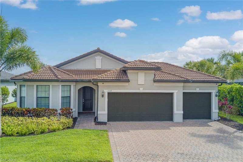 Mediterranean / spanish home featuring an attached garage, decorative driveway, stucco siding, a tiled roof, and a front yard