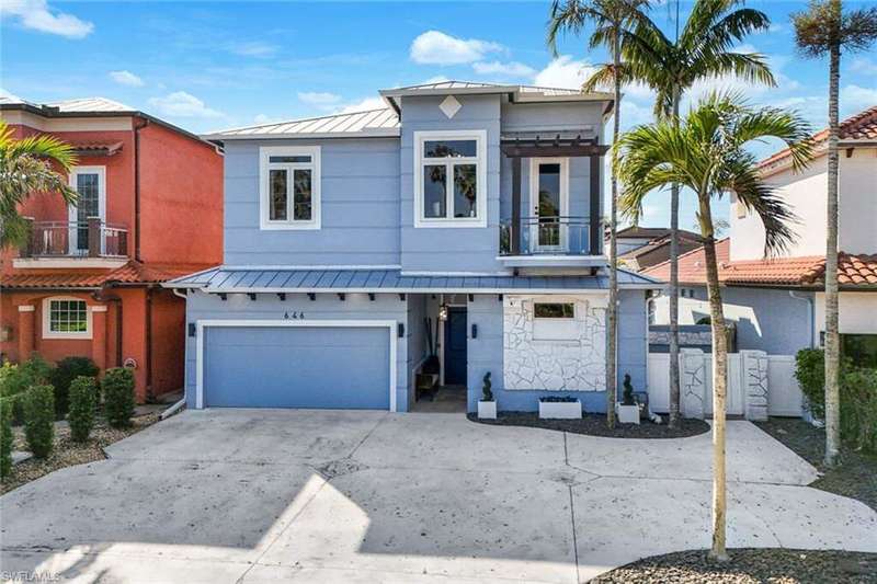 View of front of house featuring a garage and a balcony