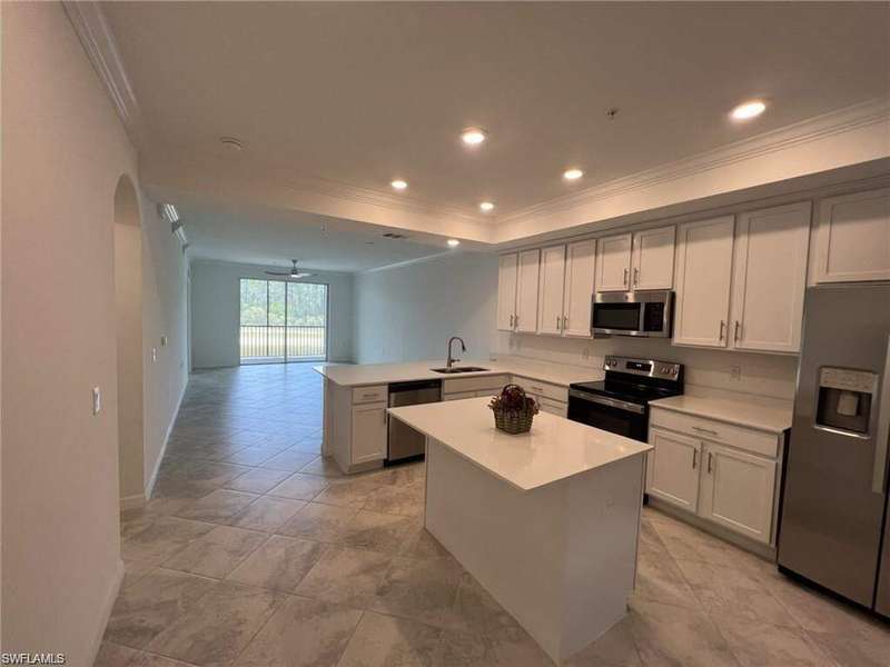 View of apartment building / complex featuring covered parking