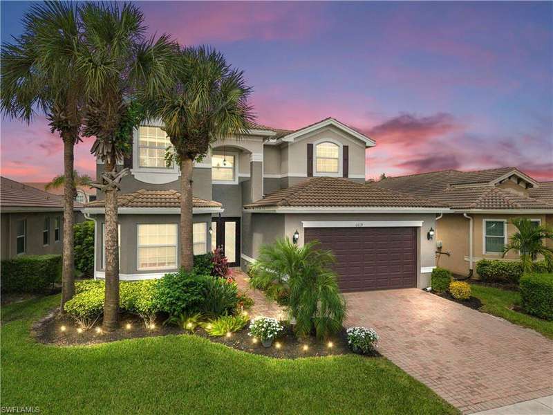 Mediterranean / spanish home with stucco siding, decorative driveway, a yard, and a tile roof