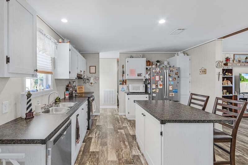 Manufactured / mobile home with a detached garage, an outbuilding, and concrete driveway
