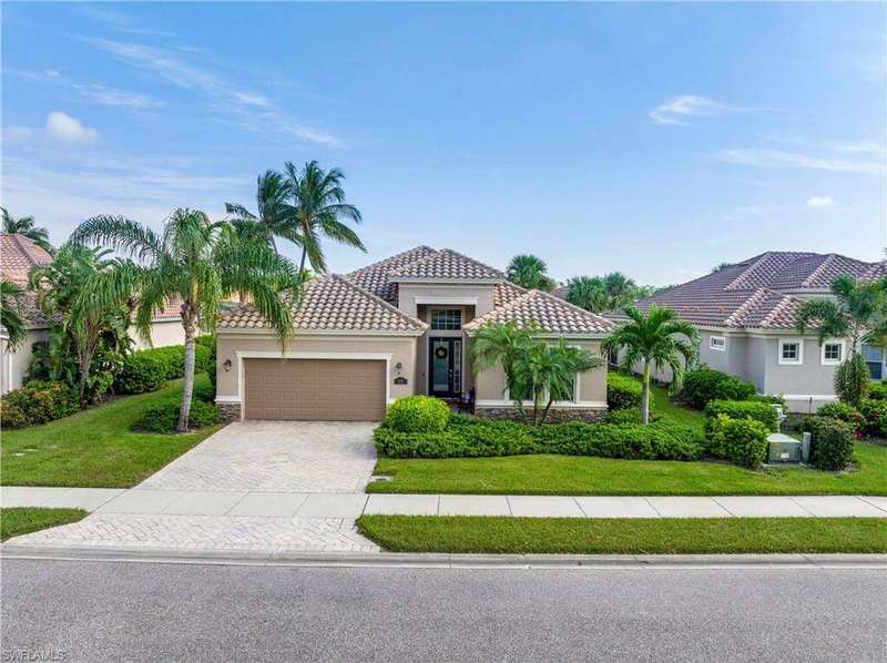 Mediterranean / spanish-style home featuring a front lawn and a garage