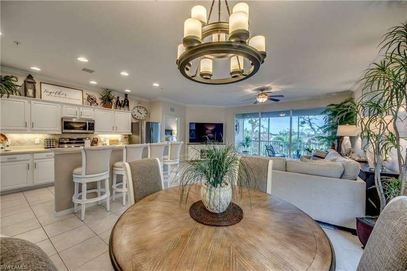 Dining room featuring ceiling fan with notable chandelier, light tile patterned flooring, and crown molding