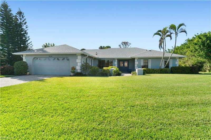 Ranch-style house featuring a garage and a front lawn