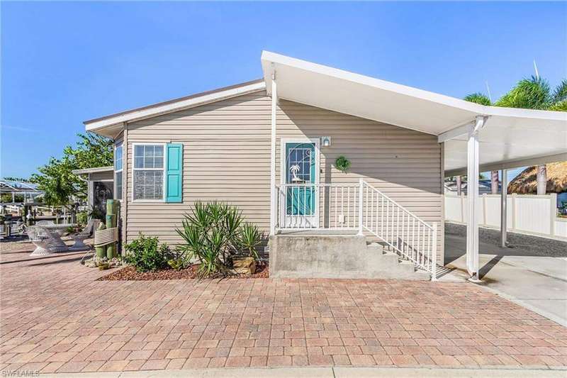 View of front of property featuring an attached carport and driveway