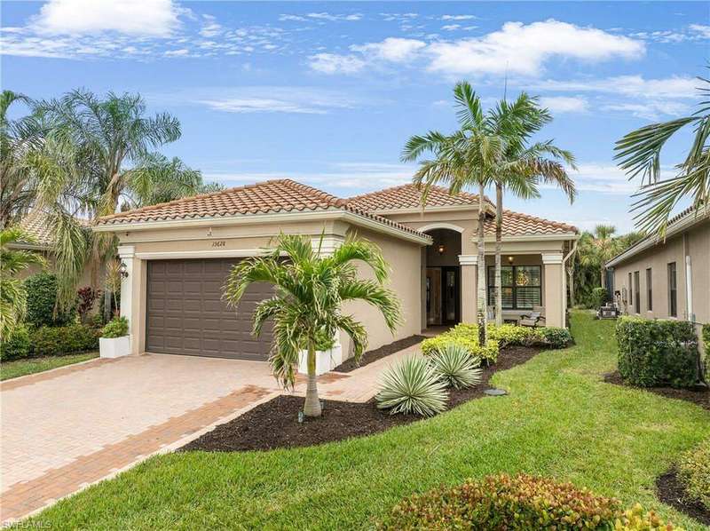Mediterranean / spanish-style house with a garage and a front lawn