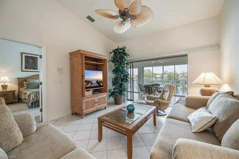 Living room with light tile patterned flooring, vaulted ceiling, and ceiling fan