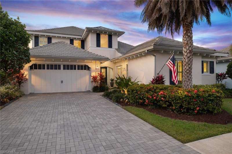 View of front of home featuring a garage, stucco siding, driveway, and a tile roof