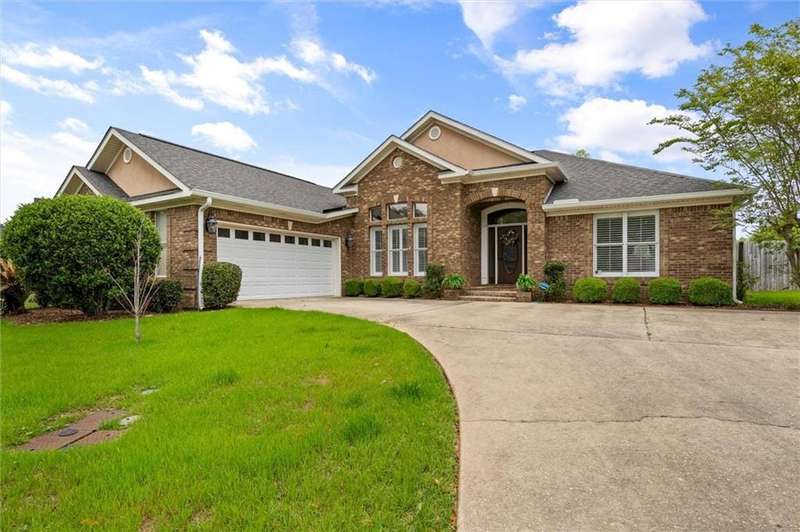 Ranch-style home featuring a front yard, a garage, brick siding, and concrete driveway