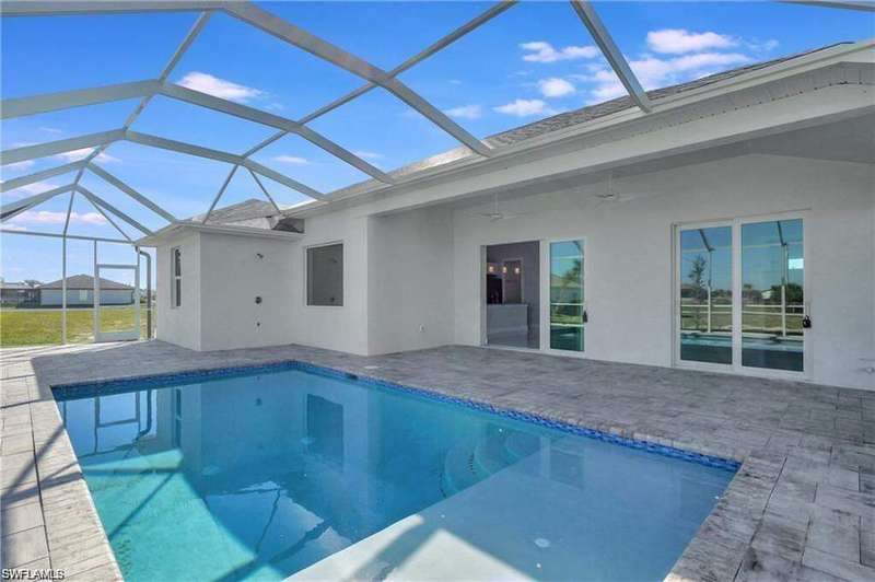 Back of house featuring an outdoor pool, a ceiling fan, a patio, and stucco siding