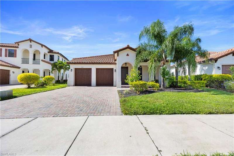 Mediterranean / spanish-style home with paved driveway, 2 car attached garage and a front porch.
