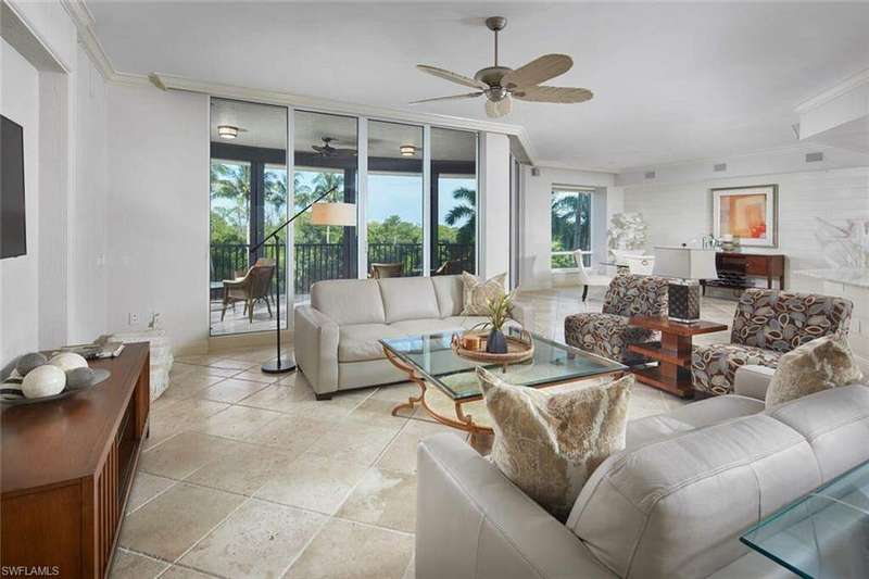 Tiled living room with ornamental molding and ceiling fan