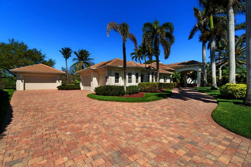 Fabulous curb appeal showcasing beautiful Tall Palm Trees along the circular driveway with an extremely rare 5 car garage.