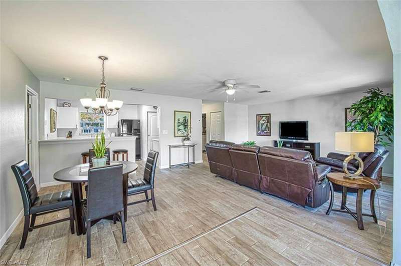 Dining space featuring ceiling fan with notable chandelier and light hardwood / wood-style floors