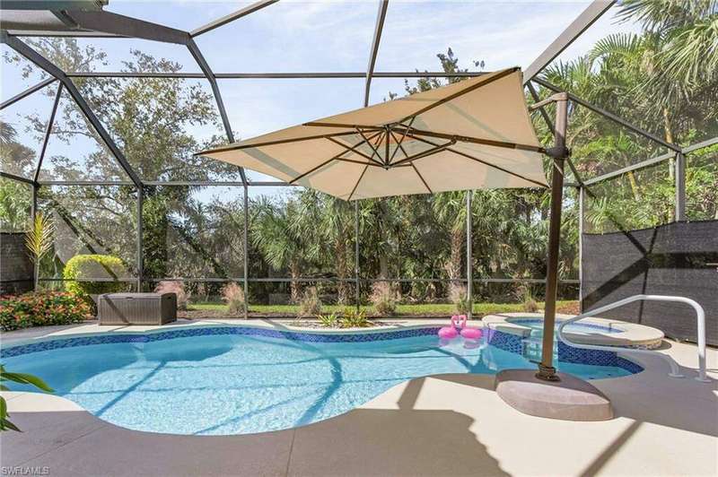 View of swimming pool with a patio, an in ground hot tub.  View of preserve.