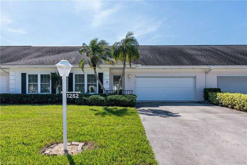 Ranch-style home with a garage and a front lawn