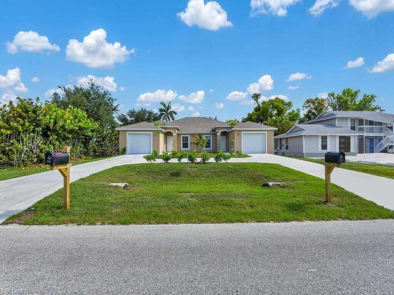 Single story home with driveway, an attached garage, and a front yard