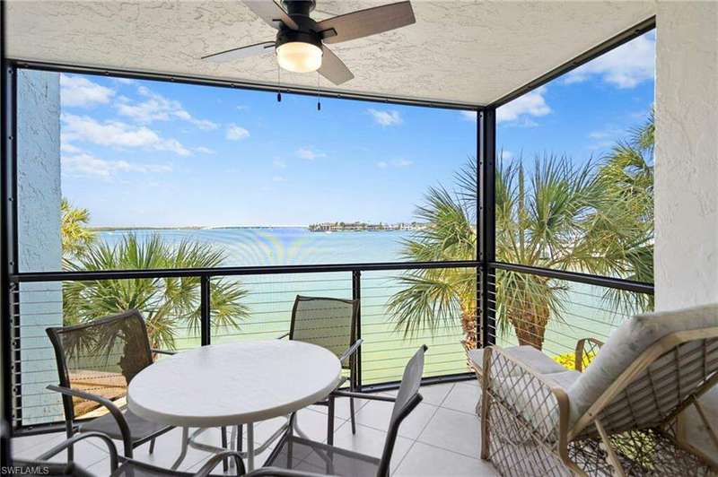 Sunroom / solarium with a wealth of natural light, a water view, and ceiling fan