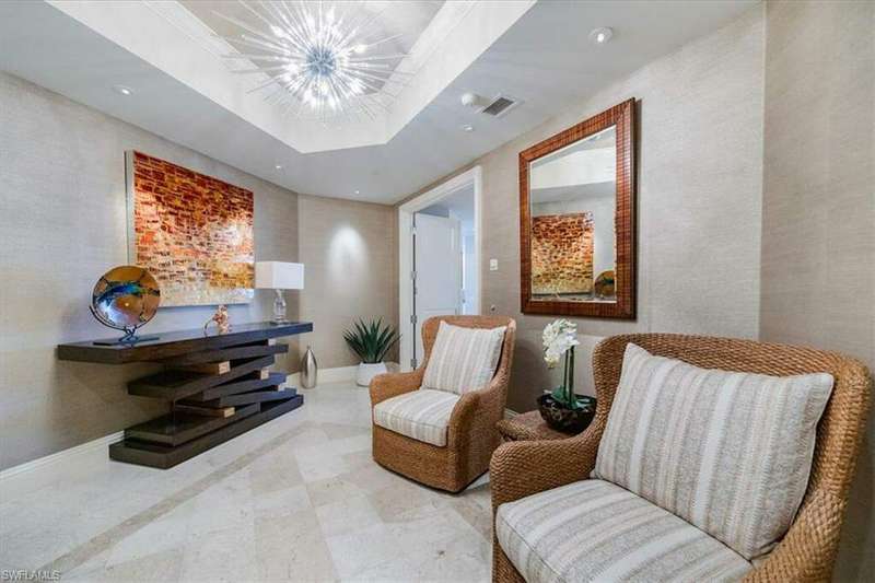 Living area featuring a notable chandelier and a tray ceiling