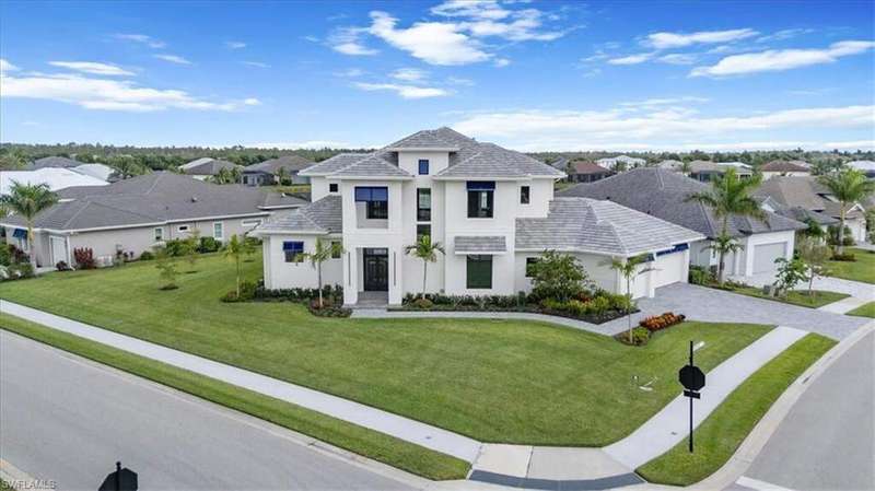 View of front of home featuring stucco siding, an attached garage, decorative driveway, a front yard, and a residential view