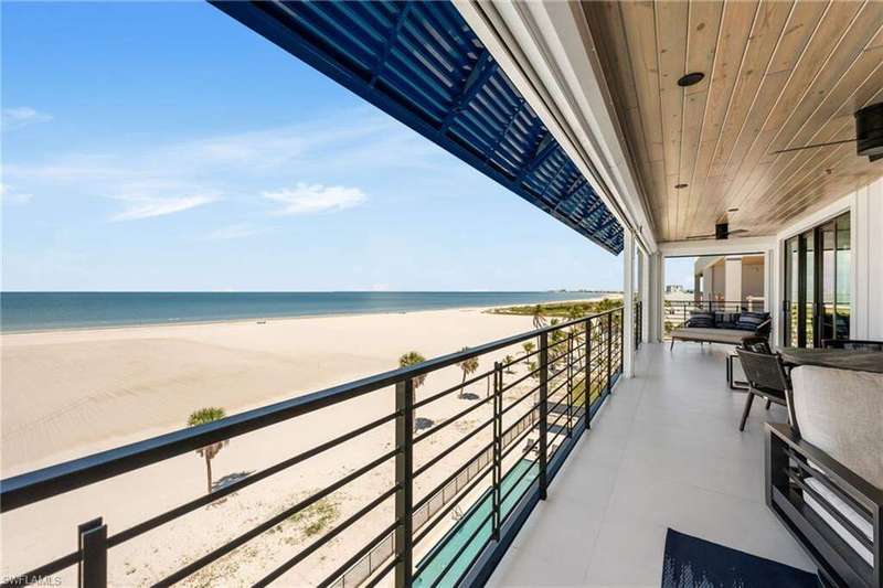Balcony featuring view of water and beach