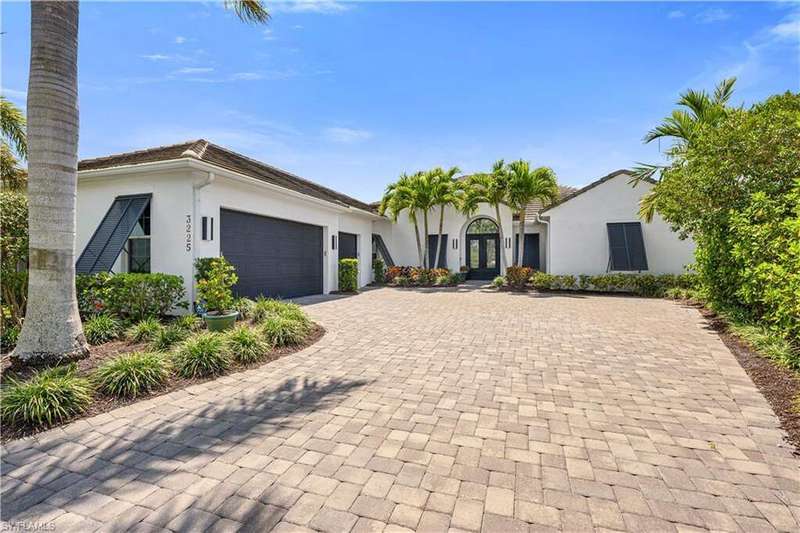 View of front of house with decorative driveway, stucco siding, an attached garage, and french doors