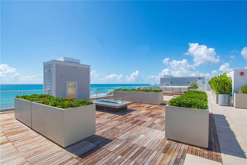 Wooden deck with a water view and a fire pit