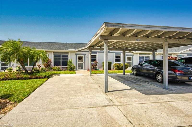 View of front of home with stucco siding and covered parking