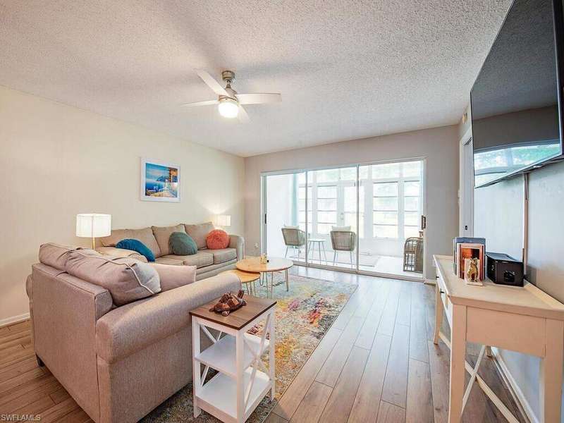 Living room featuring ceiling fan, wood finished floors, plenty of natural light, and a textured ceiling