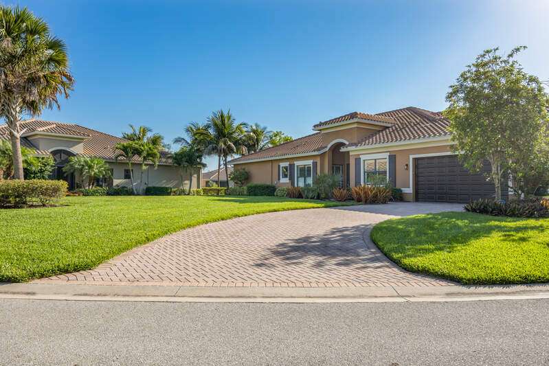 Mediterranean / spanish-style house featuring decorative driveway, a front yard, a garage, stucco siding, and a tiled roof
