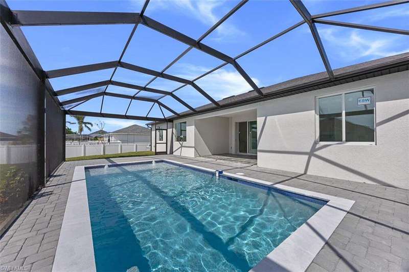 View of swimming pool featuring glass enclosure, a patio, a fenced in pool, and fence