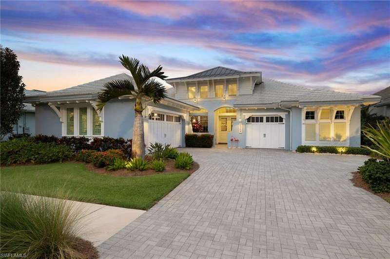 View of front of home with a yard and a garage