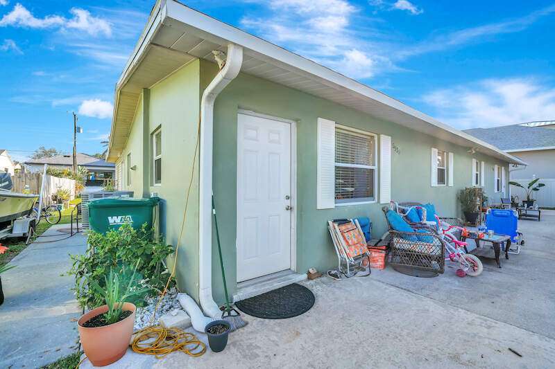 View of property exterior featuring fence and a yard