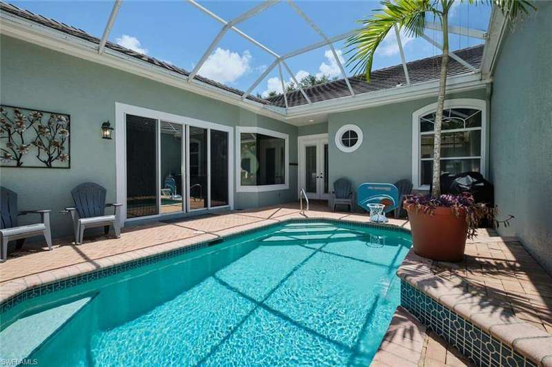 View of swimming pool with a lanai, a patio area, and pool water feature