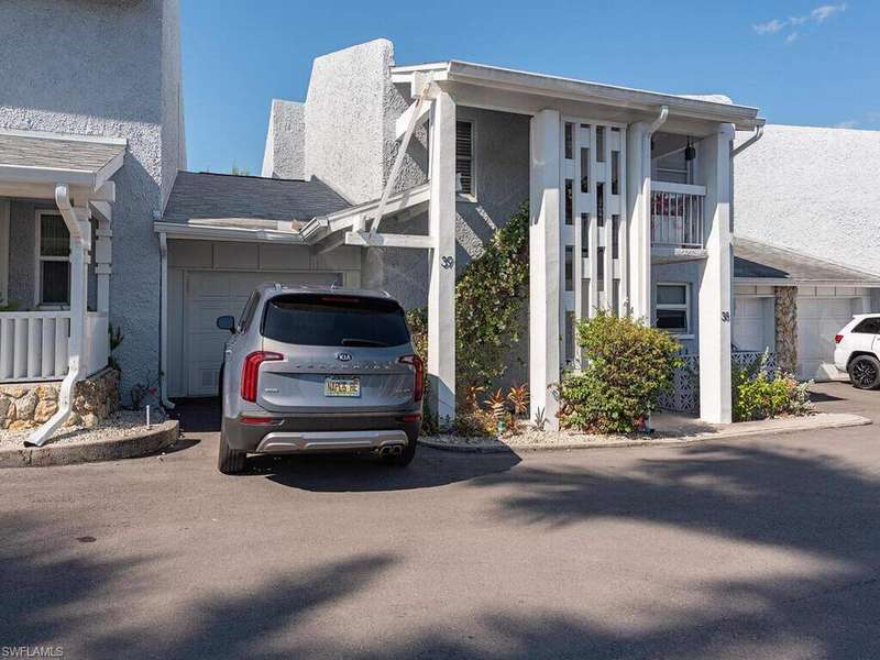 View of side of property with an attached garage, driveway, and stucco siding