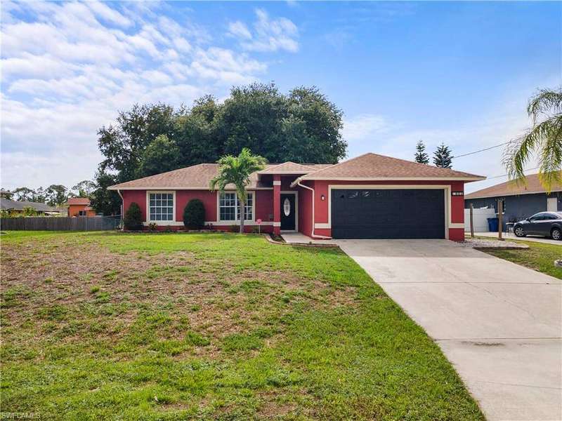 Ranch-style home featuring a garage, driveway, and stucco siding