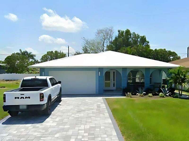 Single story home featuring a garage and a front lawn