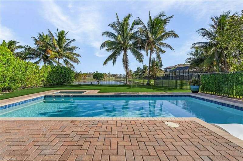 View of swimming pool featuring an in ground hot tub, a yard, and a water view