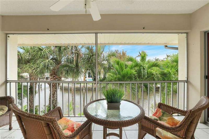 Screened lanai with a ceiling fan is perfect for a sunrise cup of coffee and a relaxing water view