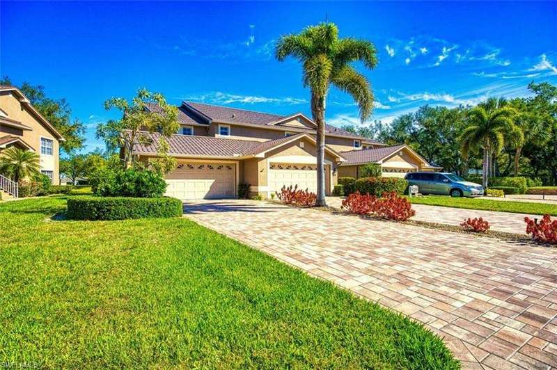 View of front of home with a front yard, stucco siding, a garage, a tile roof, and decorative driveway