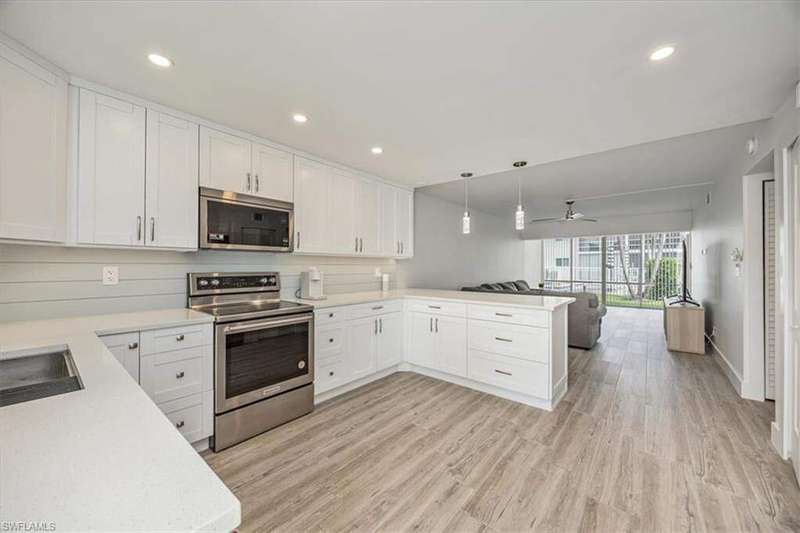 Kitchen with pendant lighting, appliances with stainless steel finishes, white cabinets, and recessed lighting