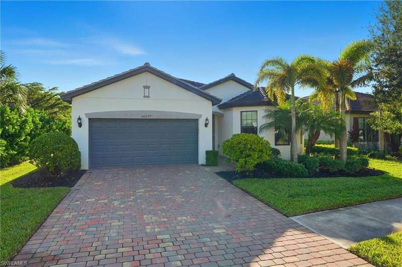 Ranch-style house with stucco siding, a front lawn, an attached garage, and decorative driveway