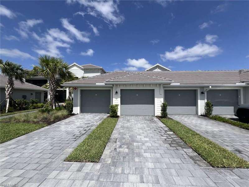 Prairie-style home featuring decorative driveway and a tiled roof