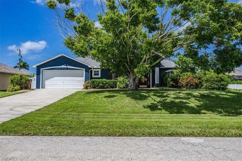 View of front of home with a garage and a front yard