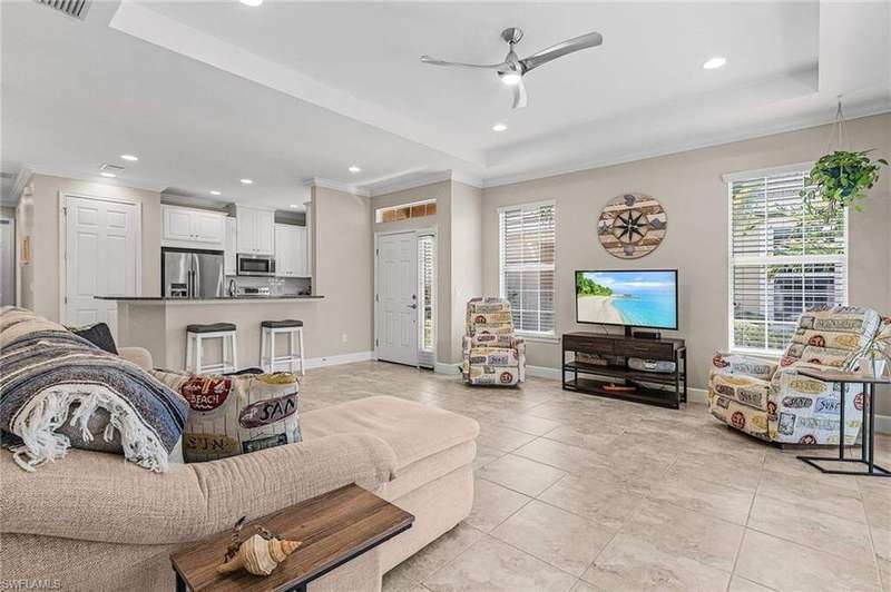 Living area with recessed lighting, light tile patterned floors, plenty of natural light, ornamental molding, and ceiling fan